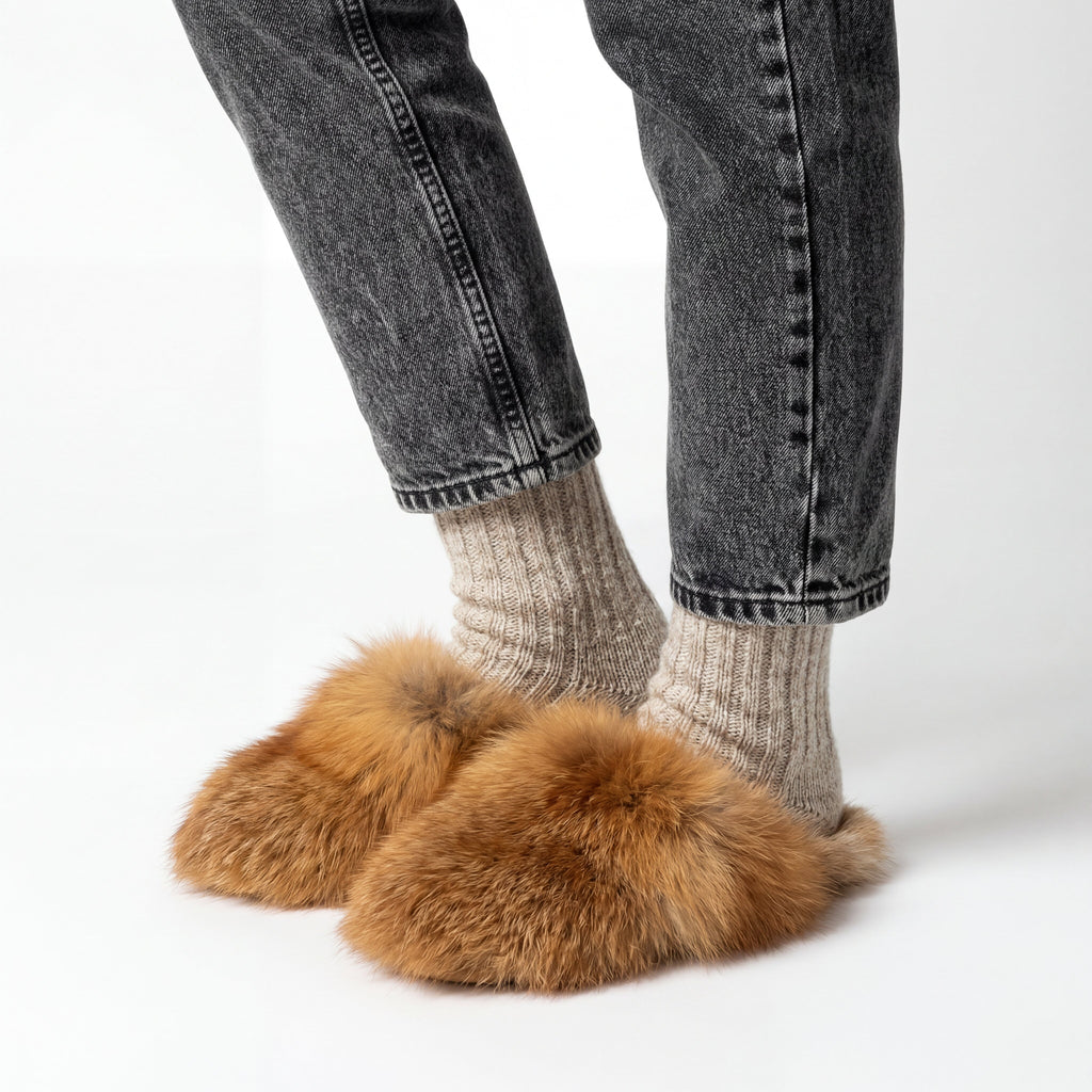 someone wearing red fox fur slippers on a white background