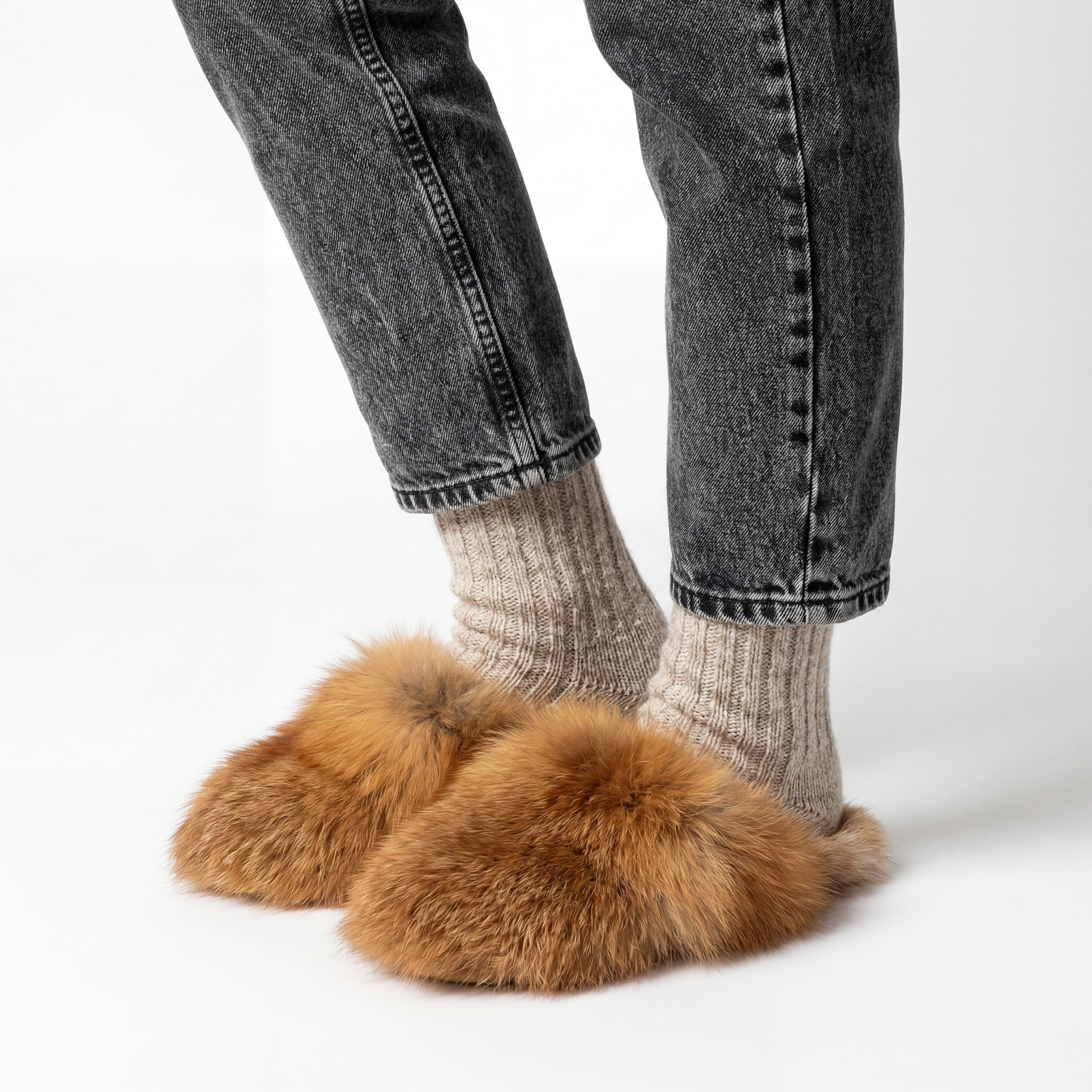 someone wearing red fox fur slippers on a white background